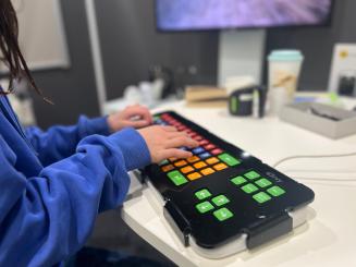 Young girl using AT keyboard with key guard and large colourful keys