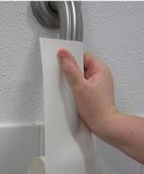 Hand adhering white tape to a handrail