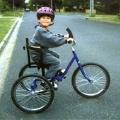 Child riding in the street on a modified tricycle