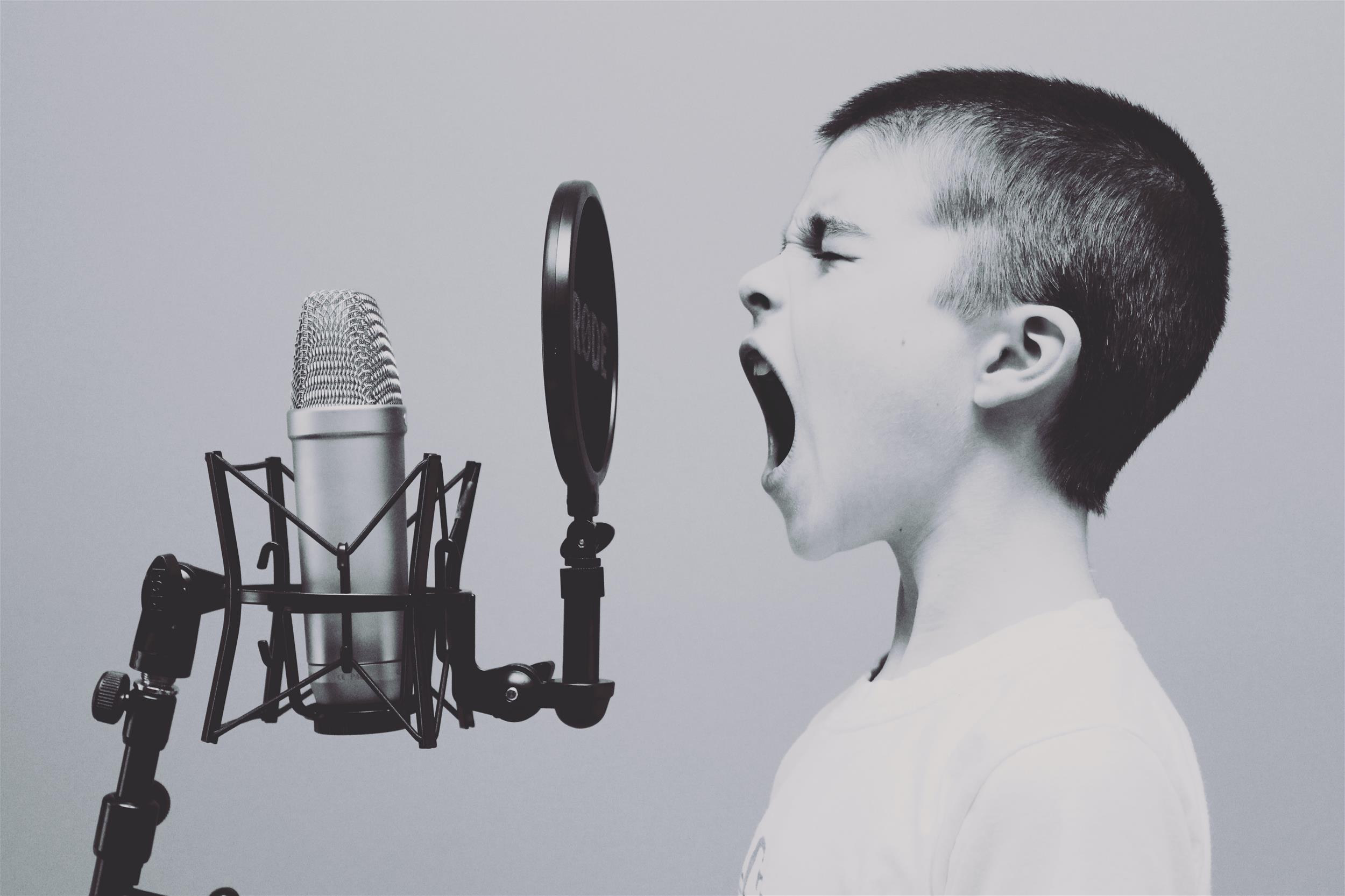 Young boy shouting into a recording microphone