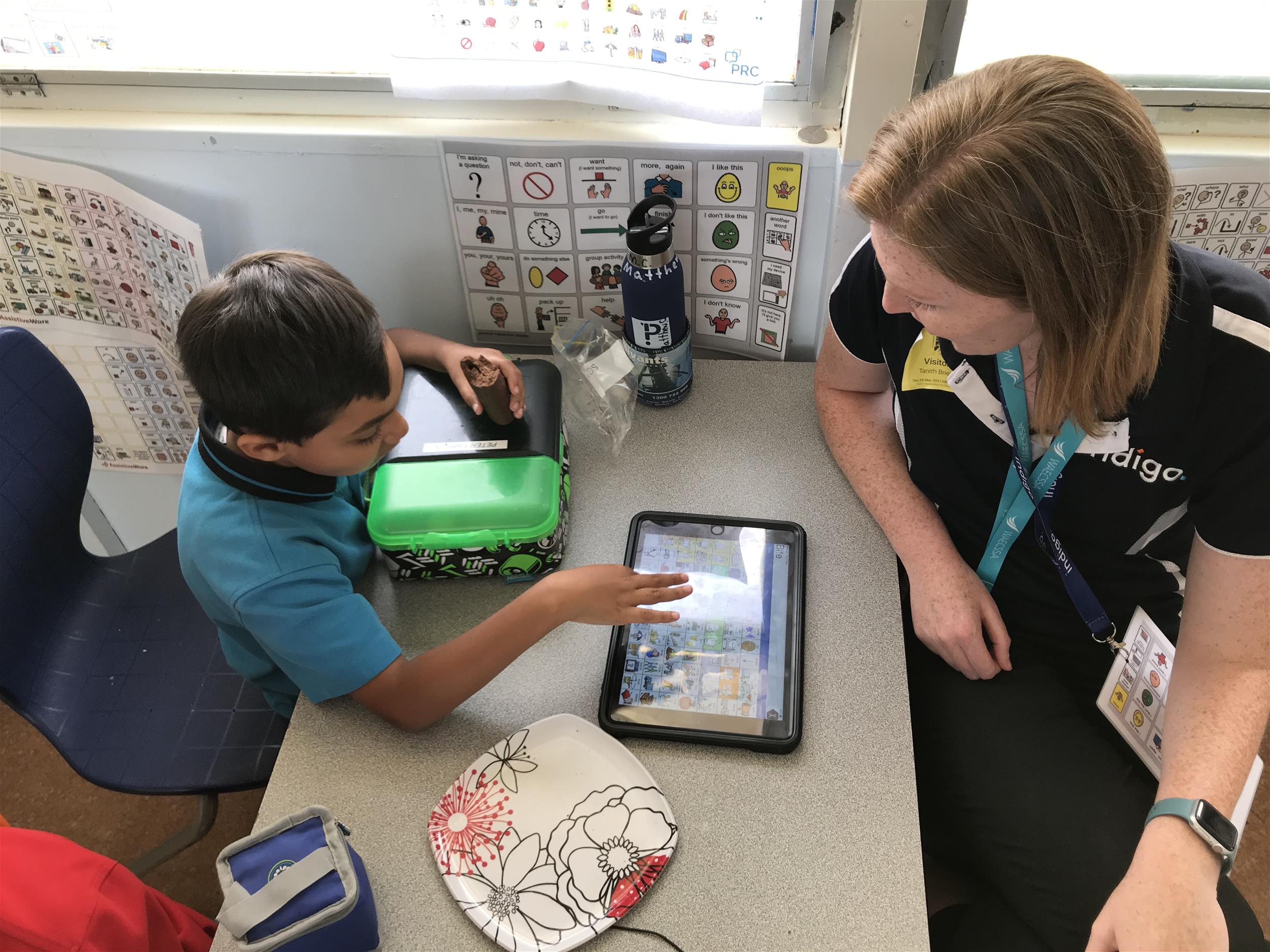 Indigo HP & young student in school using an AAC device