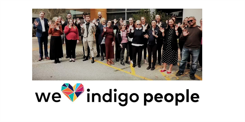 Lots of Indigo people outside waving with 'we love indigo people' below